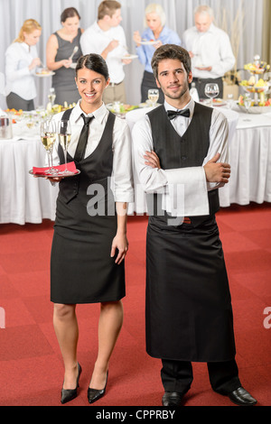 Il servizio di catering cameriere, cameriera evento aziendale che serve bevande per gli ospiti Foto Stock