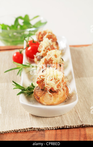 Funghi ripieni con carne macinata cosparso con formaggio grattugiato Foto Stock