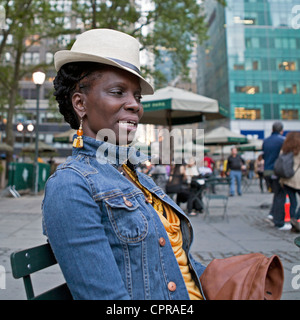 Una donna con un elegante cappello ha il suo ritratto preso in Bryant Park di New York City. Foto Stock