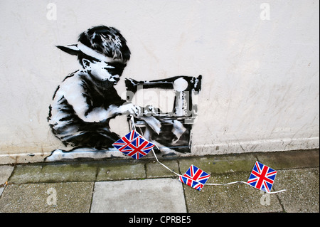 Banksy graffiti del Chinese Boy rendendo bunting in legno verde Londra davanti al jubiliee vicino Poundland Foto Stock