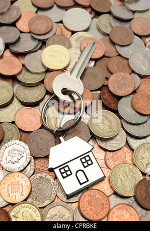 Chiave di casa in casa keyring con British denaro re i costi degli alloggi i prezzi di acquisto di ipoteche acquirenti per la prima volta il budget familiare REGNO UNITO Foto Stock