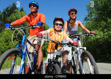 Ritratto di famiglia felice in bicicletta nel parco Foto Stock