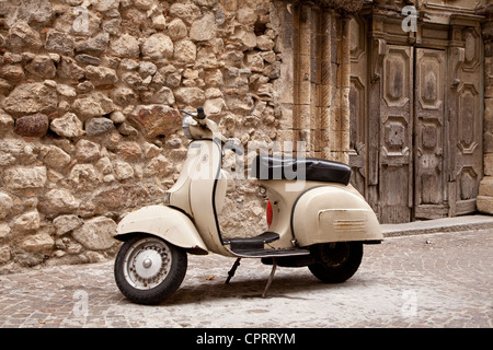 Vespa scooter parcheggiato di fronte alla vecchia chiesa, stilo, Calabria, Italia Foto Stock