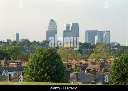 Green London, guardando verso la Canada Tower a Canary Wharf in lontananza, lo skyline della City di Londra dalla periferia sud-est di Londra, case, blocchi di alberi in primo piano. 2010 2010 UK HOMER SYKES Foto Stock