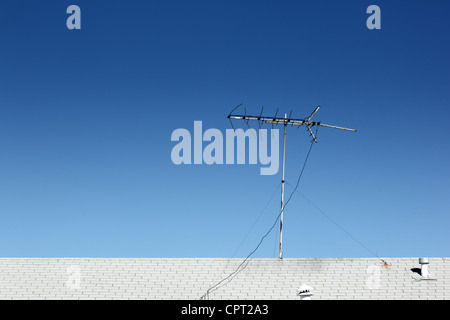 Antenna TV sul tetto sopra il cielo blu sullo sfondo. Foto Stock