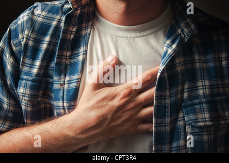 Giovane uomo adulto colpito da un grave dolore al petto. Foto Stock