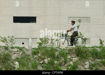 JI'an, Jilin, Cina; 20/05/2012. Un nord coreano è visto alla guida della sua bicicletta lungo le rive del fiume Yalu. Foto Stock