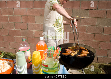 L'uomo la cottura di alimenti al di fuori sul barbecue Foto Stock