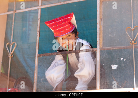 Lago Titikaka, Taquile island, Perù, bambino guardando fuori della finestra in abbigliamento celebrational Foto Stock