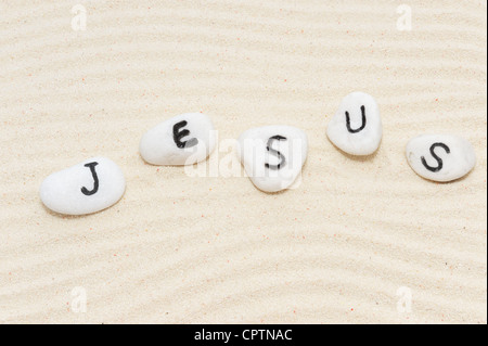 Parola di Gesù sul gruppo di pietre con Sfondo sabbia Foto Stock