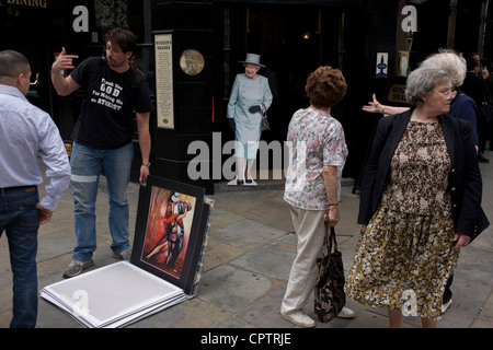 I londinesi in strada con una vita di cartone di dimensioni ritaglio della regina Elisabetta sorge all'entrata di un pub nella città di Londra in vista di un fine settimana di celebrazioni a livello nazionale per il monarca del Giubileo di diamante. Foto Stock
