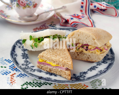 Uovo mayo il prosciutto bianco su integrali e incoronazione pollo in ciabatta con germogli di ravanello Foto Stock