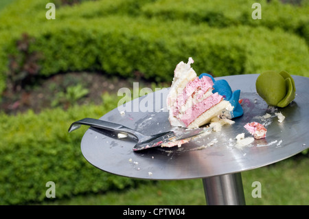 Un pezzo di torta di nozze su un supporto in un giardino. Foto Stock