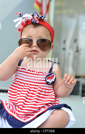 Baby girl indossando occhiali da sole grandi e rosso bianco e blu, presso il Memorial Day cerimonia tenutasi il 28 maggio 2012, in Merrick New York, Stati Uniti d'America Foto Stock