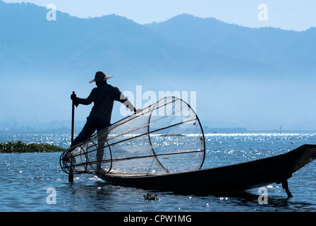 I pescatori nel Lago Inle fare una vita utilizzando una coop-come trap con net per la cattura di pesci e sono noti per le loro gambe stile di canottaggio Foto Stock