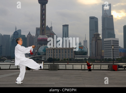 Tai Chi sword master e kite flyer sul Bund con Pudong alte torri di mattina Shanghai Repubblica Popolare Cinese Foto Stock