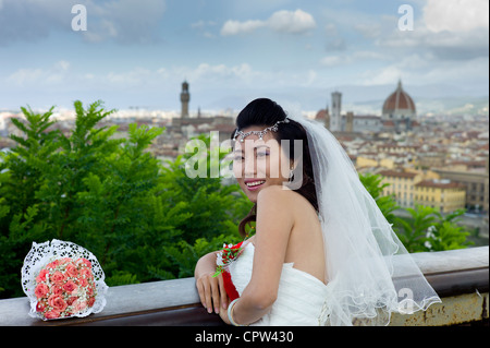 Sposa cinese pone per fotografare con sfondo della città di Firenze, Toscana, Italia Foto Stock