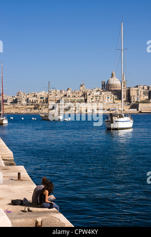 Coppia giovane godendo della vista sulla valletta dal lungomare di Sliema, Malta. Foto Stock