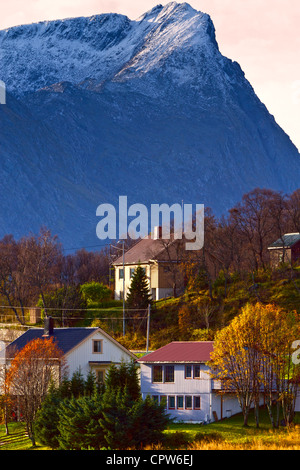 Picco di neve montagne si affacciano su una piccola cittadina norvegese. Foto Stock