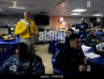 Senior Chief Aviation Boatswain's Mate (Handling) Scott Doty, capo ufficiale della divisione V-3 del Dipartimento dell'aria a bordo della compagnia aerea di classe Nimitz USS Carl Vinson (CVN 70), risponde alle domande durante la formazione del Chief Petty Officer 365 nel Mess del Capo. Carl Vinson e Carrier Air Wing (CVW) 17 sono distribuiti nella settima area operativa della flotta statunitense. Foto Stock