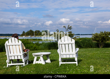 Patio sedie a fianco della Chesapeake Bay si affaccia su St Michaels harbour con maschio senior Foto Stock