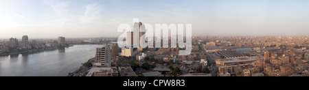 Ampia ad alta definizione panorama del fiume Nilo in Il Cairo Egitto al tramonto con un contrasto tra il moderno hotel e la baraccopoli Foto Stock