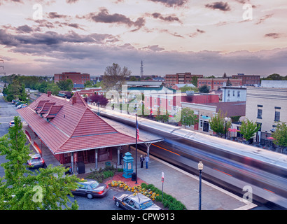 Manassas stazione ferroviaria al crepuscolo o tramonto come il treno Amtrak corre attraverso la stazione Foto Stock