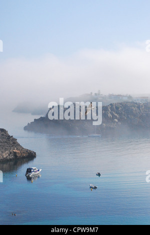 Seagull vola nella nebbia su Arenal d'en Castell Bay, a Menorca Foto Stock