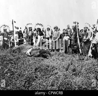 Geronimo's ultimo buffalo. Geronimo in piedi sopra morti di Buffalo, nativo per uomini e ragazzi in abito cerimoniale dietro di lui Foto Stock