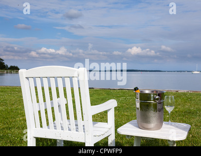 Vuota la sedia del patio e champagne nel secchiello del ghiaccio dal lato della baia di Chesapeake Foto Stock