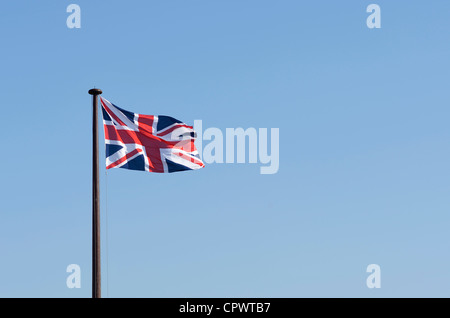 Union Jack flag battenti contro un cielo blu Foto Stock