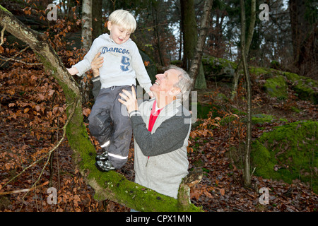 Nonno ragazzo di contenimento sul ramo di albero Foto Stock