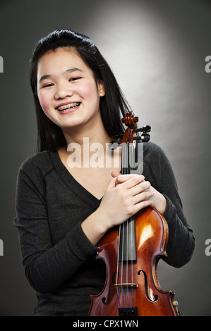 Ritratto di giovane Asian ragazza adolescente holding violino, sorridente Foto Stock