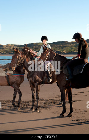 Due donne a cavallo sulla spiaggia Foto Stock