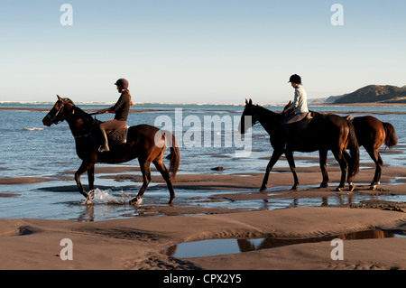 Due donne a cavallo sulla spiaggia Foto Stock