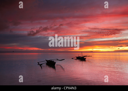 Due barche off spiaggia di San Juan al crepuscolo, Siquijor, Visayas, Filippine Foto Stock