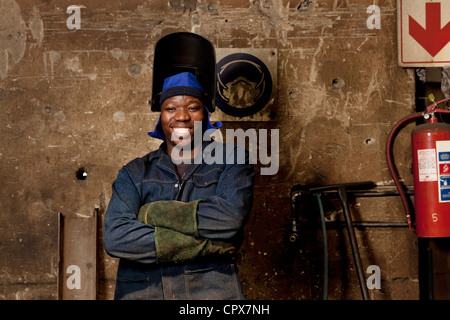 Operaio di fabbrica in posa di casco per saldatura, magnete in fabbrica, Gauteng, Sud Africa Foto Stock