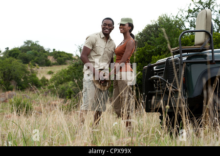 Un africano giovane in piedi insieme e tenendo le mani al fianco di una visione di gioco veicolo Foto Stock