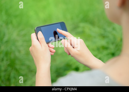 Donna che utilizza mobile smart phone nel parco. Foto Stock