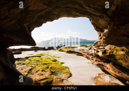 Un mare grotta nei pressi della baia di Laig a Cleadale sull'Isola di Eigg, guardando verso l'isola di rhum, Scotland, Regno Unito. Foto Stock