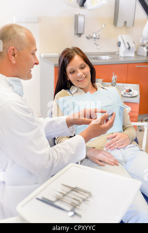 Visita al dentista che mostra paziente femmina modello di denti Foto Stock