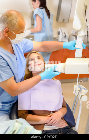 Dentista tenendo a raggi x del paziente di sesso femminile con assistenza infermiere Foto Stock