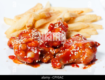 Patatine fritte e pollo in salsa di pomodoro con sesamo Foto Stock