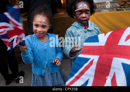 Rivington Street party, Shoreditch, Londra. Due giovani ragazze sventolando union jack e faccia diademi di vernice Foto Stock