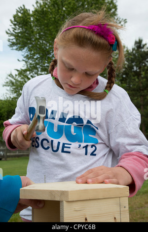 Volontari costruire case di uccelli per essere distribuiti nel loro quartiere come parte di un adolescente di Eagle progetto Scout. Foto Stock