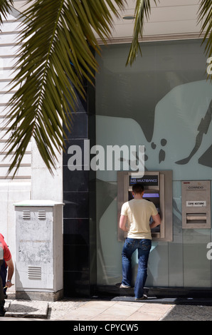 Giovane uomo tramite bancomat a Lisbona portogallo Foto Stock