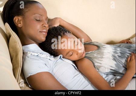 Giovane africana Madre giaceva con sua figlia su un lettino Foto Stock