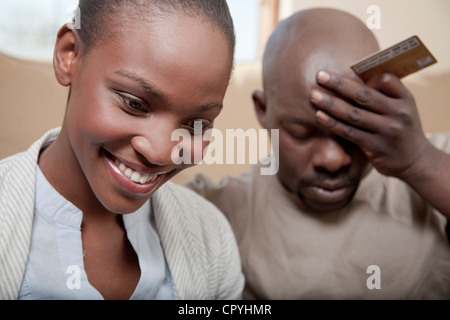 Paio di acquisto di prodotti su internet, l'uomo guarda irritata, Illovo Famiglia, Johannesburg, Sud Africa. Foto Stock