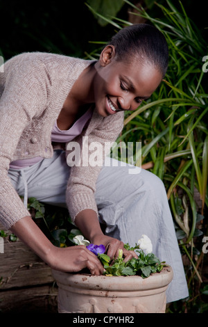 Una donna piantare fiori, Illovo Famiglia, Johannesburg, Sud Africa. Foto Stock