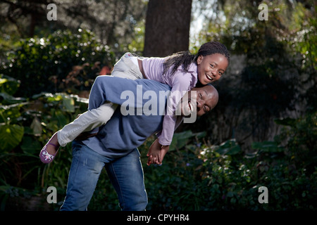 Padre e figlia insieme giocando in un giardino, Illovo Famiglia, Johannesburg, Sud Africa. Foto Stock